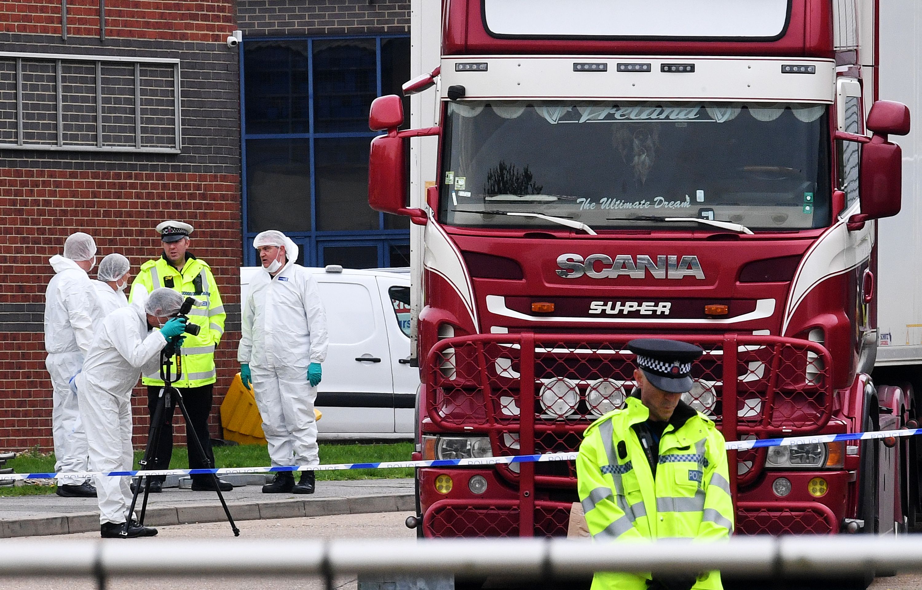 Police and forensic scientists examine the truck, in which 39 people were found dead.