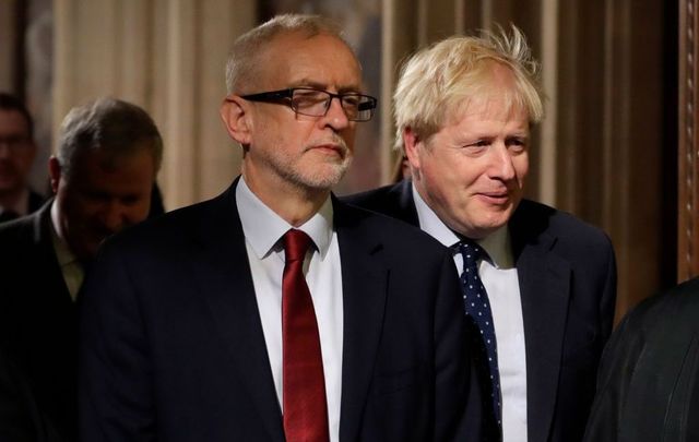 Britain\'s Prime Minister Boris Johnson (R) and opposition Labour Party Leader Jeremy Corbyn walk through the Commons Members Lobby during the State Opening of Parliament at the Palace of Westminster on October 14, 2019, in London, England. 