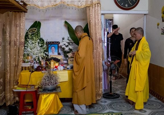 Buddhist monks pray at a makeshift shrine in the home of Pham Thi Tra My, suspected to be one of the 39 who died in a people-smuggling tragedy, discovered in Essex, England.