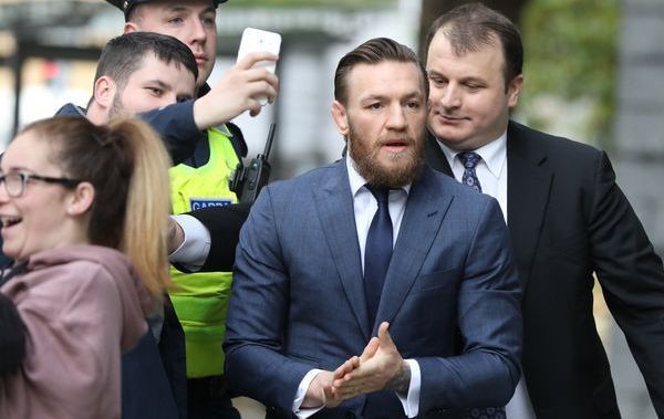 Members of the public attempt to pose for a selfie with Conor McGregor as he enters the Criminal Courts of Justice in Dublin today to face assault charges from April of this year. 