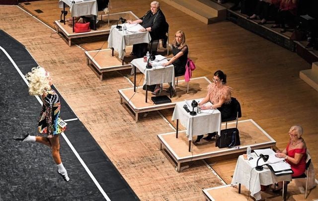 A panel of judges observes an Irish dancer at the 2018 CLRG World Irish Dancing Championships.