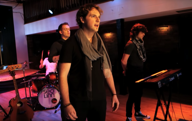 Stiofan Ó\'Fearail, front, sings with Seo Linn band members 