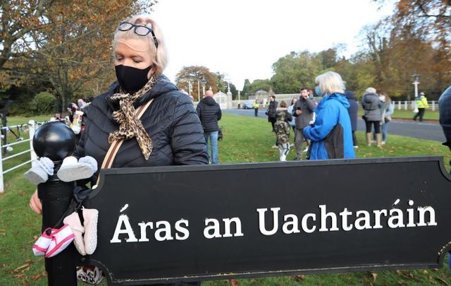 October 26, 2020: Protesters tie baby shoes to a gate during a Mother and Baby Home protest event at Aras an Uachtarain gate in Dublin. 