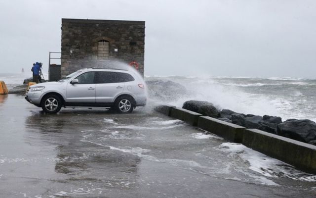 A car is showered in sea spray as Storm Brendan hits in January. 