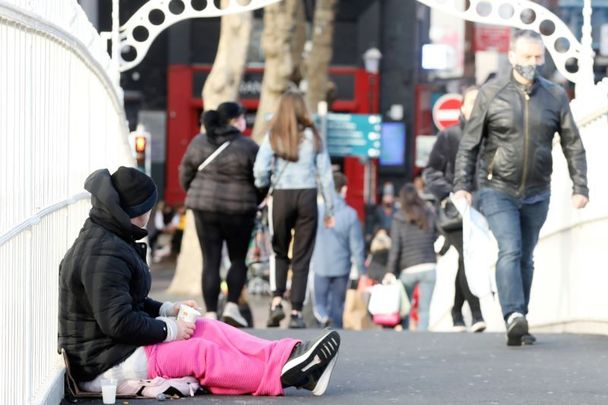 December 2, 2020: A person begging on Ha’Penny Bridge in Dublin