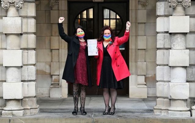 December 7, 2020: Cara McCann (R) and her partner Amanda McGurk (L) hold their marriage certificate aloft as they leave Belfast City Hall in Belfast, Northern Ireland.