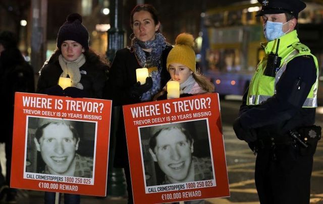 December 7, 2020: Michele Deely with her daughters Lily and Nina and members of the gardai at a vigil for the 20th Anniversary of the Disappearance of Trevor Deely. 