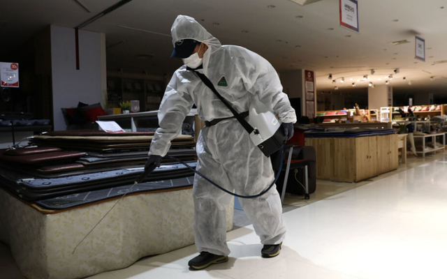 A South Korean health official searches for traces of Coronavirus in a department store