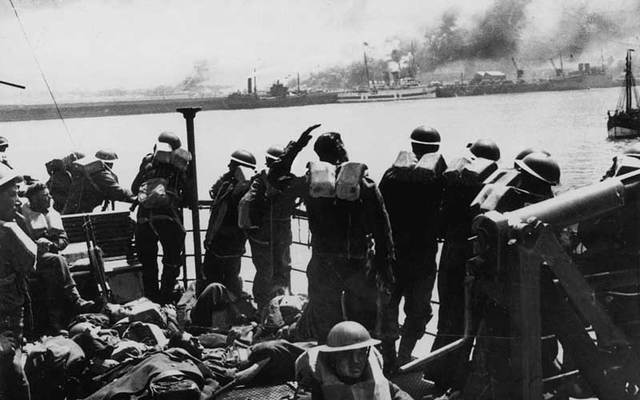 British troops looking back at the French coast from the deck of a steamer on the return to England after the evacuation of Dunkirk, June 1940.