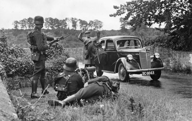 25th July 1939: A driver is searched by armed guards at a military checkpoint on a country road in Ireland during the Second World War. 
