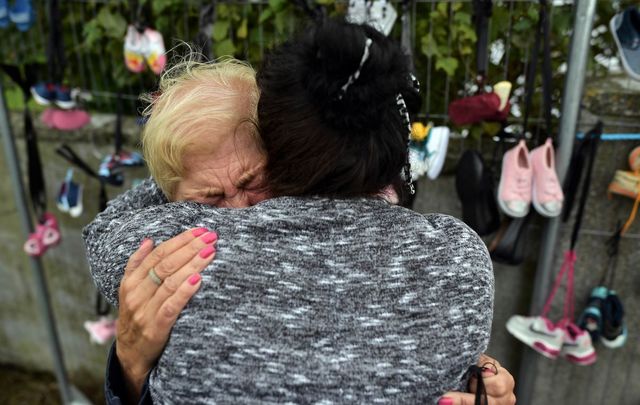 A woman who lost her daughter in the Tuam babies scandal is comforted as a vigil takes place at the site of the mass grave which contained the remains of 796 named babies from the Bon Secours Mother and Baby home on August 26, 2018 in Tuam, Co Galway.