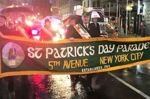 Malachy McAllister, Sean Lane, and Hilary Beirne hold the parade’s banner.