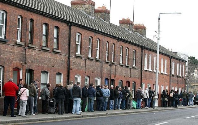 People queue in Dun Laoghaire, Dublin to collect their social welfare payments in 2009.