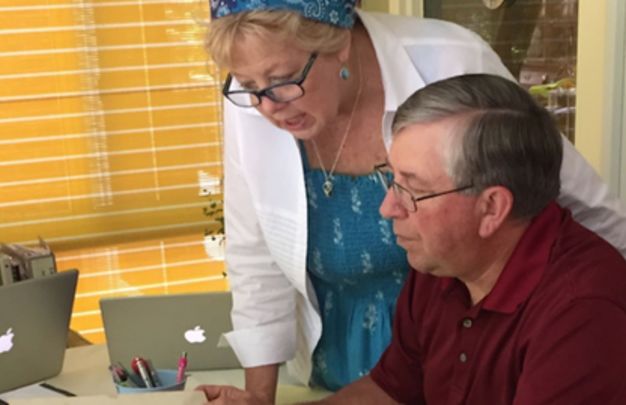 Kate and Mike reviewing family records in the Kennedy family bible passed down through four generations.
