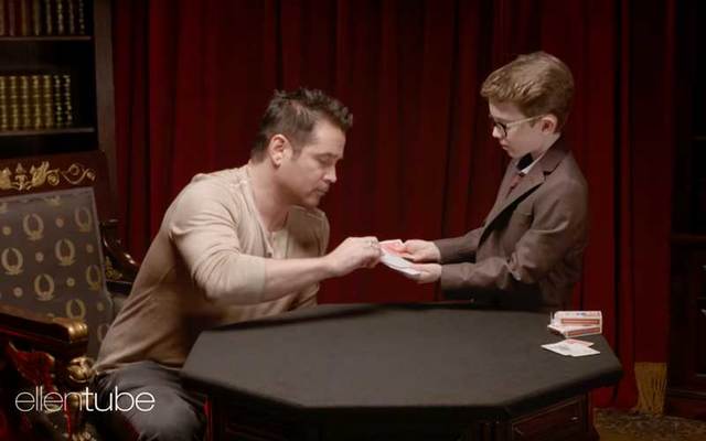 Actor Colin Farrell picks a card for Irish kid magician Aidan McCann.