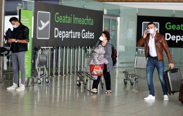 Passengers wearing face masks in an almost deserted Terminal One in Dublin Airport on April 25, 2020.