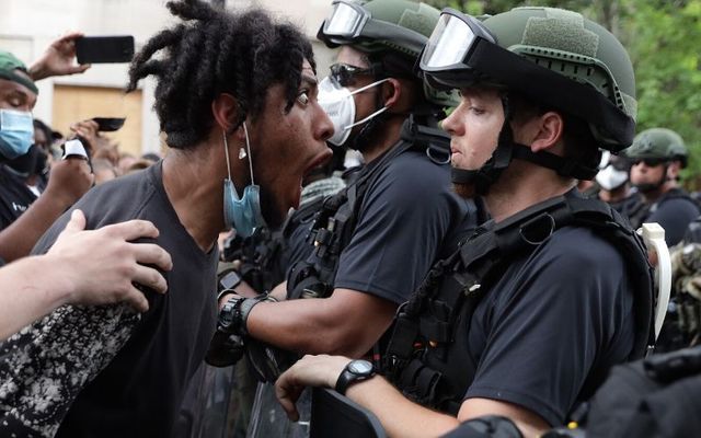 A protestor shouts at a law enforcement officer during a protest in Washington DC. 