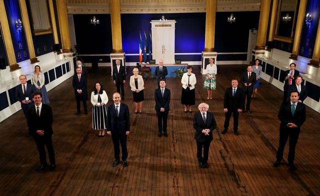 President Michael D Higgins presents a seal of office to the 15 members of Ireland\'s new government, led by Micheal Martin.
