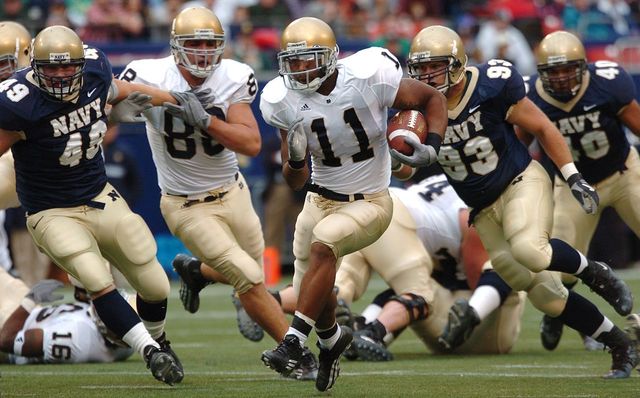 Notre Dame running back Marcus Wilson races for yardage as a trio of U.S. Naval Academy Midshipmen defenders gives chase at Giants Stadium in East Rutherford, N.J, in Oct 2004.