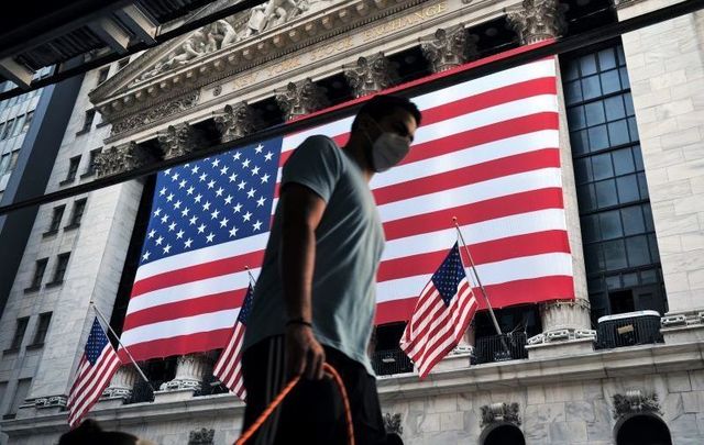 September 11, 2020: A man wearing a face mask walks by the New York Stock Exchange in New York City.