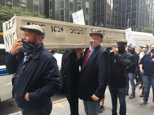 Attendees at the rally carry a makeshift casket symbolizing the death of the city’s hospitality industry.