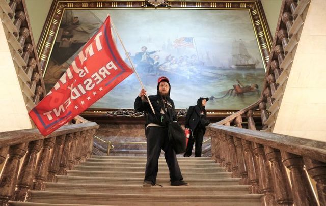 January 6, 2021: A pro-Trump rioter holds a Trump flag inside the US Capitol Building near the Senate Chamber in Washington, DC.