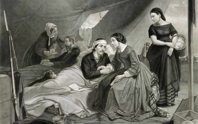 Women attend to wounded soldiers in a hospital tent during the Civil War in this vintage illustration.