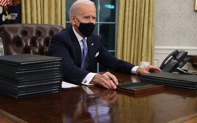 January 20, 2021: President Joe Biden signs a series of executive orders at the Resolute Desk in the Oval Office. 