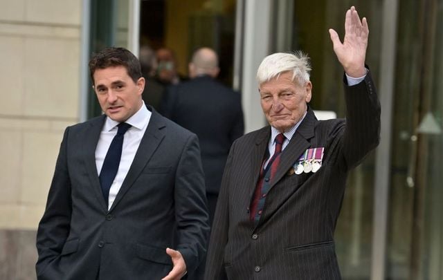 October 4, 2021; Dennis Hutchings (R) waves as he arrives at Laganside Court alongside former Conservative minister Johnny Mercer (L) in Belfast, Northern Ireland. Hutchings, a former member of the Life Guards regiment, has denied a charge of attempted murder in relation to the death of John Pat Cunningham, a 27-year-old man with learning difficulties who was shot dead as he ran from an Army patrol near Benburb, County Tyrone, in 1974. Hutchings has been a high-profile campaigner for veterans of the Northern Ireland conflict to receive greater protections from criminal prosecutions.