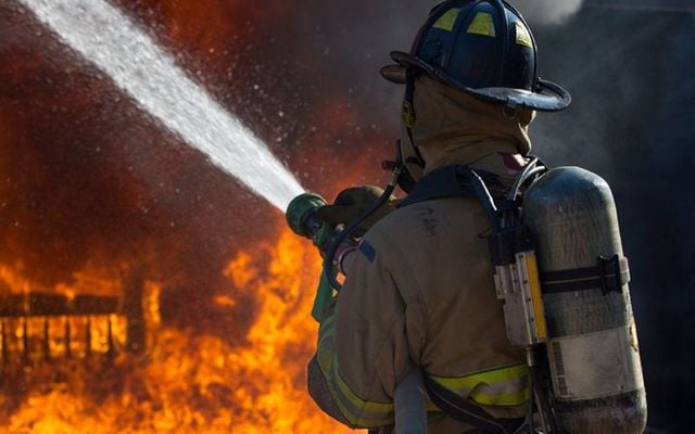 A fireman fights a raging house fire. (STOCK PHOTO)