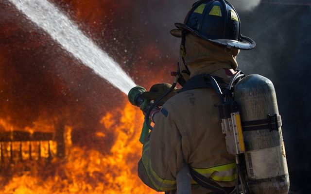 A fireman fights a raging house fire. (STOCK PHOTO)