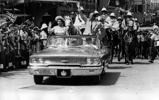 February 18, 1966: The Queen and Prince Philip driving through Barbados waving to the crowds.