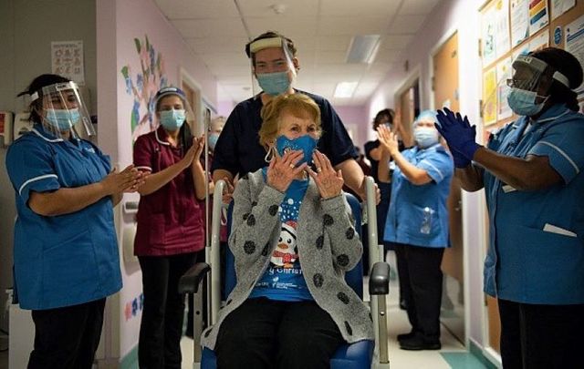 December 8, 2020: Margaret Keenan, 90, is applauded by staff as she returns to her ward after becoming the first person in the United Kingdom to receive the Pfizer/BioNtech covid-19 vaccine at University Hospital at the start of the largest ever immunization programme in the UK\'s history in Coventry, United Kingdom.