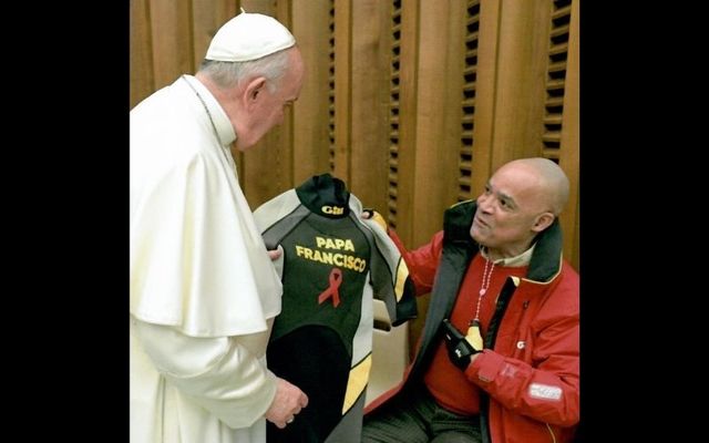 Don Victor Mooney presents Pope Francis with a wetsuit at the Vatican on World AIDS Day. 