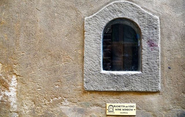 Detail of an old \"buchetta del vino\", a small window on the exterior wall of the ancient palaces used to sell wine to passers-by, Florence, Tuscany, Italy.