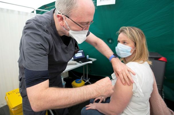 January 16, 2021: GP and Member of the National Covid Liaison committee Dr. Ray Walley administering the Moderna vaccine to GP Kathleen Mcclory Malahide Family Practice at the HSE National Ambulance Service HQ in conjunction with HSE Public Health.