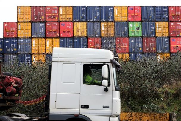 A truck passes cargo containers at Dublin Port on February 1, 2021.