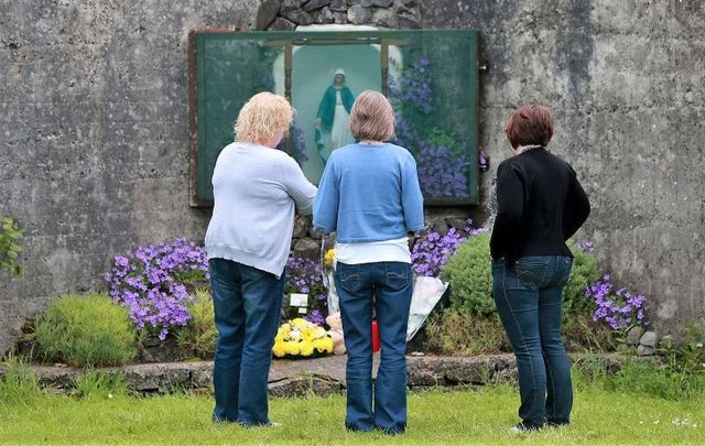 June 7, 2014: Members of the public pay their respects at the grounds where the unmarked mass grave containing the remains of nearly 800 infants who died at the Bon Secours mother-and-baby home in Tuam Co Galway from 1925-1961 rests.