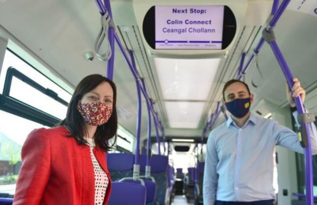 Northern Ireland\'s Infrastructure Minister Nichola Mallon and Piarais MacAlastair from Forbairt Feirste celebrate the launch of Irish language signs on West Belfast Gliders.