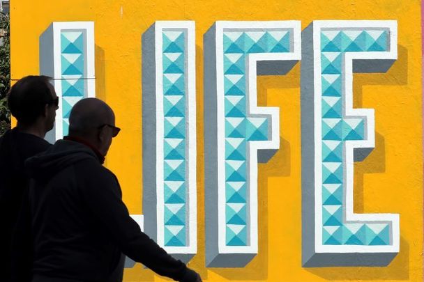 April 26, 2021: People pass by murals in the Dublin Docklands area crafted by Vanessa Power (@signs_of_power).