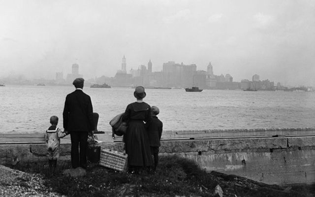 An immigrant family viewing New York City from Ellis Island, in 1925.