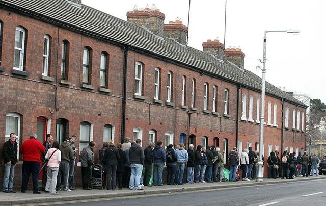 March 2009: People queue down Cumberland Street, Dun Laoghaire to collect their social welfare payments. 