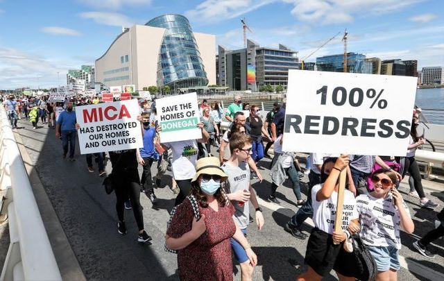 June 15, 2021: Large crowds of people crossing Samuel Beckett Bridge in Dublin as they march from the Convention Centre to Leinster House in support of a 100% redress scheme for homeowners affected by the mica scandal. 