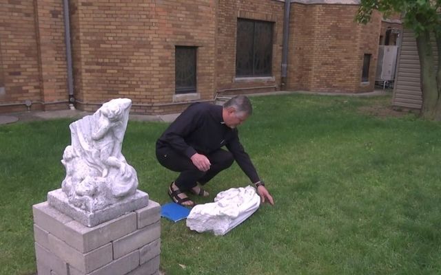 Father Miroslaw Podymniak examines the vandalism of a statue at St. Adalbert Church in Elmhurst, Queens. 