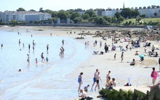 Crowds flock to Seapoint in Dublin during a period of fine summer weather. \n