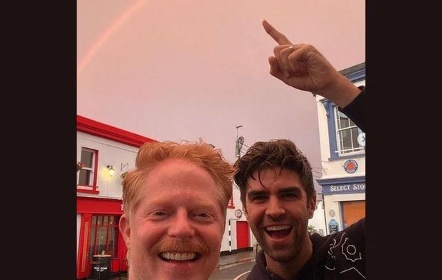 Jesse Tyler Ferguson and his husband Justin Mikita pose underneath a rainbow in Dalkey. 