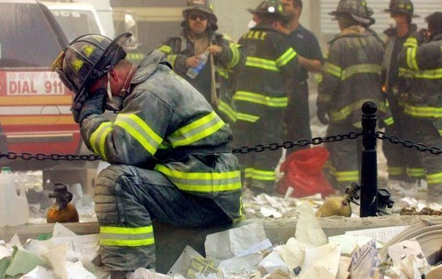 A firefighter pauses during search and rescue efforts on 9/11. 