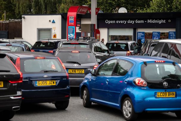 Cars line up outside a gas station in England.