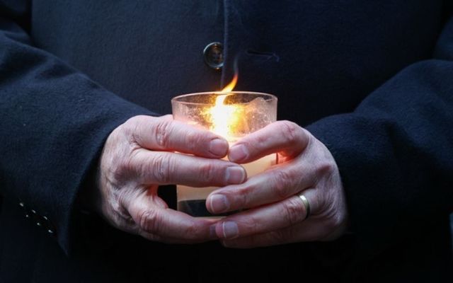 Taoiseach Micheál Martin holds a candle at a vigil for Ashling Murphy outside Dáil Eireann on Friday afternoon. 