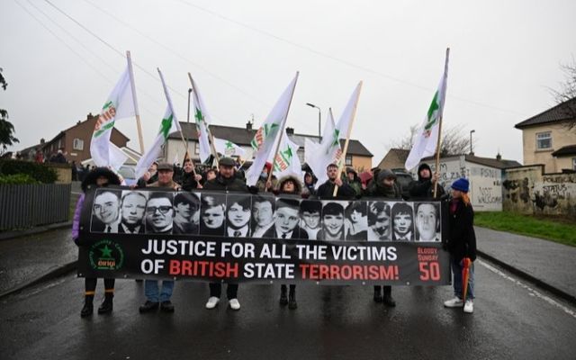 Families of Bloody Sunday victims hold up a banner calling for justice. 